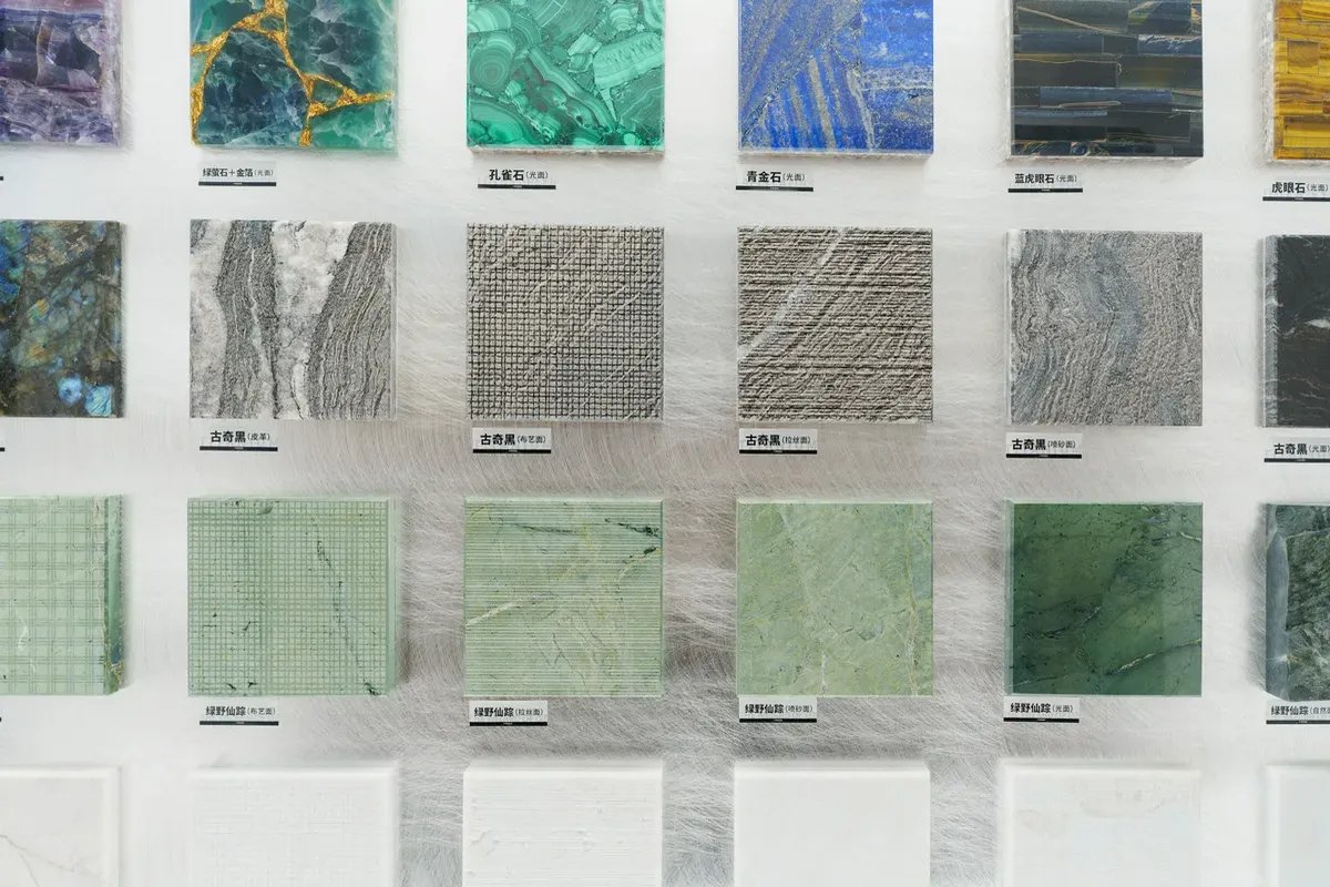 Marble and stone samples in several colours and veining patterns laid out together on a display table.
